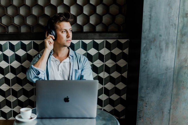 man with headphones and macbook