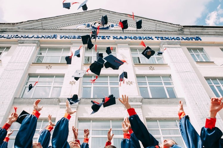 Students throwing their mortar boards in the air